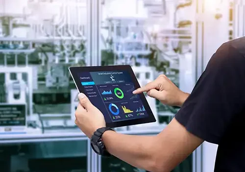 An image of a person holding an ipad with technical graphs on it.