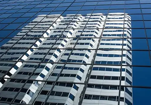 Banner image of a building's reflection of another building.